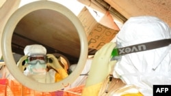 FILE - Medical staff prepare as part of the fight against the Ebola virus at the Donka hospital in Conakry, March 8, 2015.