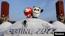工人在北京冬奥会场馆树起冬奥会吉祥物冰墩墩和雪容融。（2022年1月11日）