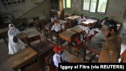 Siswa dan guru memakai masker setelah pemerintah membuka kembali sekolah sebagai ilustrasi. KPAI mencatat ada belasan kasus kekerasan yang terjadi di satuan pendidikan selama 2021. (Foto: Antara/Iggoy el Fitra via Reuters)