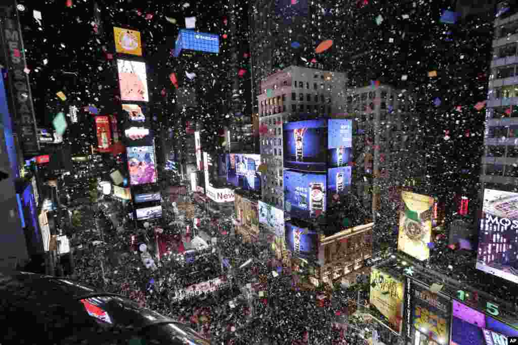 Confetti drops over the crowd as the clock strikes midnight during the New Year's celebration in Times Square as seen from the Marriott Marquis in New York, Jan. 1, 2018.