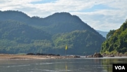 Bendera kuning di pinggiran Sungai Mekong menandai lokasi yang diilih untuk konstruksi Luang Prabang dekat Desa Houaygno, Laos, 4 November 2019. (Zsombor Peter/VOA)