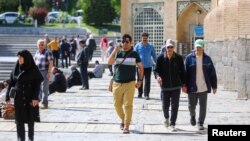 Warga Iran menikmati hari yang cerah di sepanjang Sungai Zayandeh Rud, pasca adanya laporan serangan Israel terhadap Iran, di Provinsi Isfahan Jumat (19/4). 