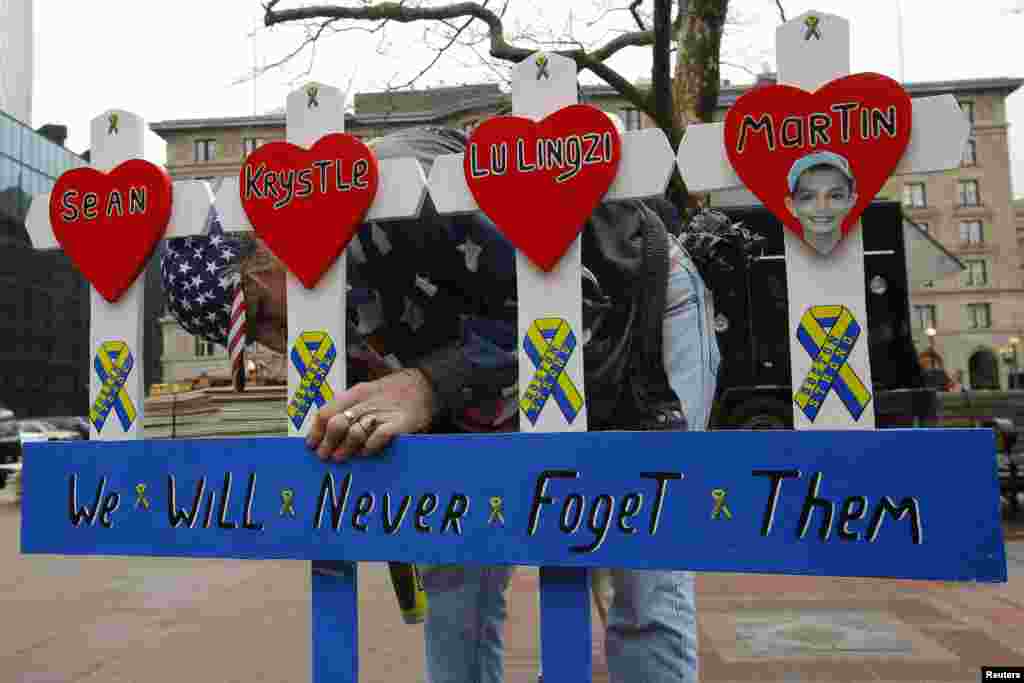 Kevin Brown puts up a handmade memorial for victims of the 2013 Boston Marathon bombings near the race's finish line in Massachusetts, April 15, 2014.