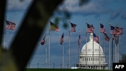 រូបឯកសារ៖ កំពូល​អាគារ​វិមាន​សភា​សហរដ្ឋអាមេរិក នៅពីក្រោយ​ដងទង់ជាតិសហរដ្ឋអាមេរិកនៅក្នុង​​រដ្ឋធានីវ៉ាស៊ីនតោន ថ្ងៃទី ១០ ខែមេសា ឆ្នាំ ២០២០។