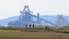 FILE - People play golf near the Tata Steel plant in Hartlepool in north east England on May 3, 2021.