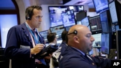 交易员在纽约证券交易所交易大厅内工作。（2015年7月8日，美联社）