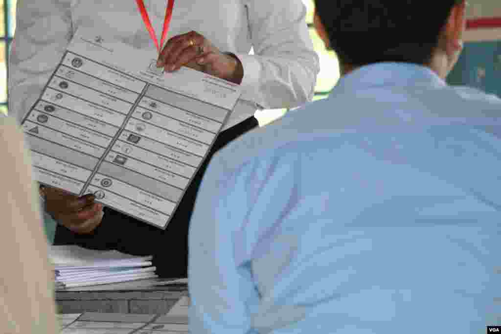 មន្ត្រីរៀបចំការបោះឆ្នោតលើកបង្ហាញសន្លឹកឆ្នោតមួយសន្លឹក​​ បន្ទាប់ពីការិយាល័យ​បោះឆ្នោតនៅទូទាំងប្រទេសបានបិទ នៅឃុំសារិកាកែវ ស្រុកល្វាឯម ខេត្តកណ្តាល ថ្ងៃអាទិត្យ​ ទី២៩ ខែកក្កដា​ ឆ្នាំ២០១៨។ (ស៊ុន ណារិន/VOA)