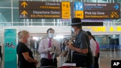 Virus Outbreak IndonesiWarga Australia diperiksa satpam saat keberangkatan di Bandara Internasional Ngurah Rai, Bali, Rabu, 18 Agustus 2021. (Foto: AP/Firdia Lisnawati)