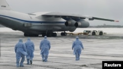 身穿防护服的俄罗斯医务人员走向从中国武汉撤回俄罗斯与东欧国家侨民的军机。（2020年2月5日）