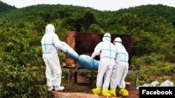 ភ្នាក់ងារសុខាភិបាលចាត់ចែងបូជាសាកសពអ្នកជំងឺកូវីដ១៩ម្នាក់នៅស្រុកកំពង់ត្រាច ខេត្តកំពត កាល​ពី​ខែមិថុនា ឆ្នាំ២០២១។ (រូបថត៖ ហ្វេសប៊ុក​ស្នងការដ្ឋាននគរបាលខេត្តកំពត) 