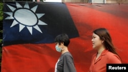 资料照：人们从台北街头的台湾旗帜旁走过。（2020年8月10日）