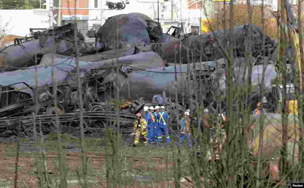A firefighter and an emergency crew work on the site of the train wreck in Lac Megantic, Quebec, July 16, 2013.