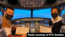 Precious Sibalo, right, and Abdulaziz Belkhair show off certificates for completing multicrew cooperation training on an Airbus 320 flight simulator. (Courtesy PTC Aviation) 