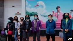 FILE - People wait to cross a street in Hong Kong, Jan. 9, 2022.