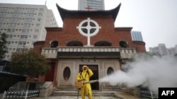 一名工人在武汉汉口教堂救世堂前为防疫新冠病毒喷洒消毒药水。（2020年3月6日）