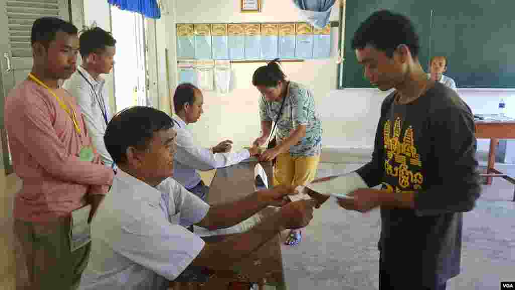 People walk along the cliff-top above the lighthouse at Beachy Head near Eastbourne on the south coast of England following an easing of lockdown rules in England during the COVID-19 pandemic.