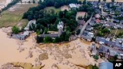 A damaged castle, left, is seen in Erftstadt-Blessem, Germany, July 17, 2021.