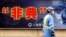City employee wearing protective mask walks past local government anti-SARS advertisement, Shanghai, Dec. 29, 2003.
