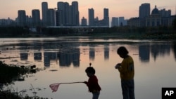 FILE - Children play near the pond at the "Fish Tail" sponge park that's built on a former coal ash dump site in Nanchang in north-central China's Jiangxi province on Oct. 30, 2022.