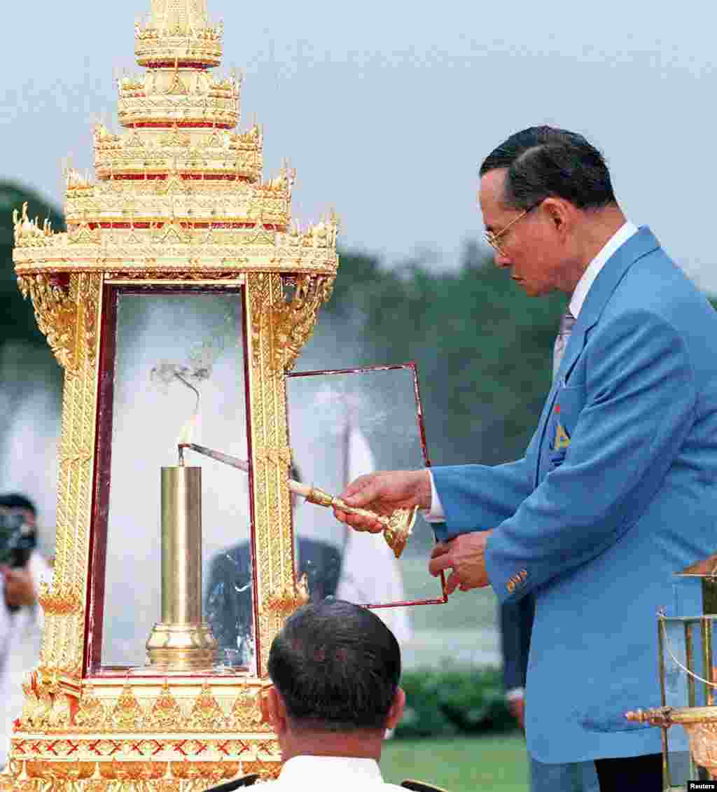 King Bhumibol lights the flame for the 13th Asian Games, Dec. 3, 1998, during a ceremony at Chitrlada Palace, the King's residence, during a ceremony three days prior to the start of the games.