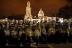 FILE - District of Columbia National Guard stand outside the Capitol, January 6, 2021, after a day of rioting protesters.