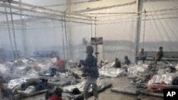 File - This March 20, 2021, photo provided by the Office of Rep. Henry Cuellar, D-Texas, shows detainees in a Customs and Border Protection (CBP) temporary overflow facility in Donna, Texas.