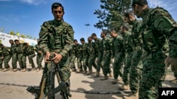 Borci Sirijskih demokratskih snaga (SDF), koje predvode Kurdi a podržava Amerika, u blizini naftnog polja Omar u istočnoj Siriji, igraju nakon proglašenja totalne eliminacije i poslednjeg bastiona Islamske države (IS), 23. marta 2019.