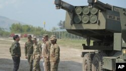 2023年4月26日，菲律宾总统小费迪南德·马科斯（Ferdinand Marcos Jr.) （左）在美菲“肩并肩”中观看美国 M142 高机动火炮火箭系统 (HIMARS)。