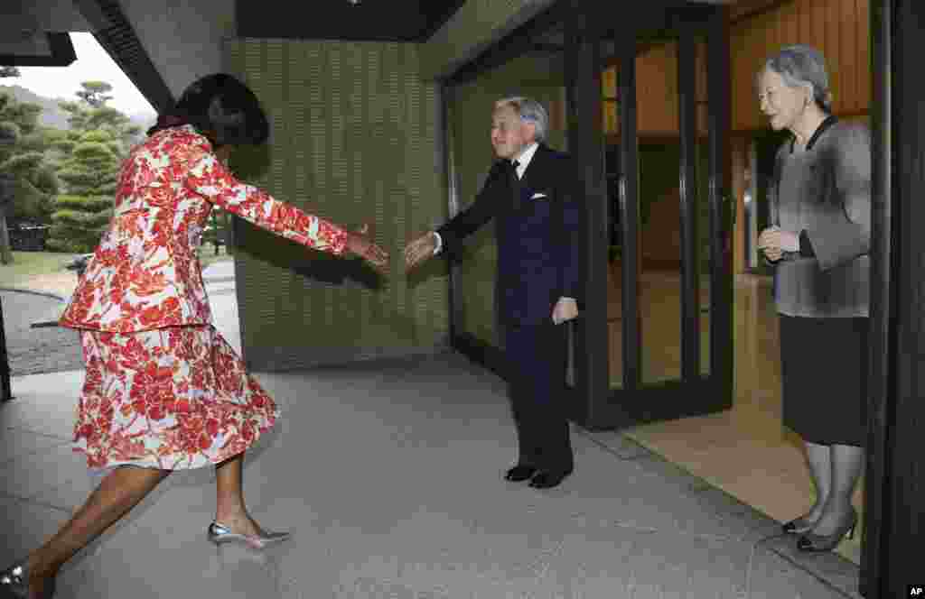 Ibu Negara AS Michelle Obama hampir jatuh sebelum bersalaman dengan Kaisar Jepang Akihito, tengah, sementara Permaisuri Michiko mendampingi ketika ia tiba di Istana Kekaisaran di Tokyo.