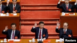 中国共产党第十九次全国代表大会闭幕式上，中共总书记习近平和前总书记江泽民、胡锦涛等人举手表决（2017年10月24日）。