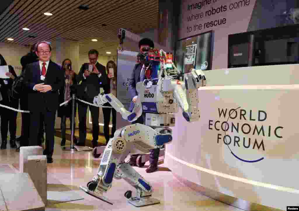 HUBO, a multifunctional walking humanoid robot performs a demonstration of its capacities next to its developer Oh Jun-Ho, Professor at the Korea Advanced Institute of Science and Technology (KAIST) during the annual meeting of the World Economic Forum (WEF) in Davos, Switzerland.