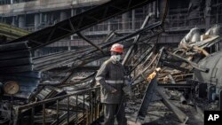 Seorang pekerja membersihkan puing-puing pembangkit listrik DTEK yang terkena serangan rudal Rusia di Ukraina, pada Selasa, 2 April 2024. (Foto: AP)