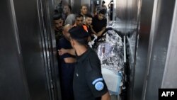 Ekipe hitne pomoći prebacuju telo američke državljanke koja je upucana na Zapadnoj obali (Foto: AFP)