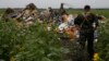 A pro-Russian separatist looks at wreckage from the nose section of a Malaysia Airlines Boeing 777 plane which was downed near the village of Rozsypne, in the Donetsk region July 18, 2014. World leaders demanded an international investigation into the sho