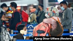 Orang-orang antre untuk check-in tiket dengan barang bawaan mereka di Bandara Soekarno-Hatta, Tangerang untuk mudik lebaran di tengah pandemi COVID-19, 4 Mewi 2021. (REUTERS/Ajeng Dinar Ulfiana)