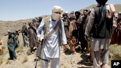 FILE - Members of a Taliban breakaway faction walk during a gathering, in Shindand district of Herat province, Afghanistan, May 27, 2016.