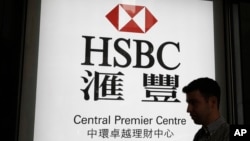 资料照：一名男子走过香港汇丰银行一个支行的广告灯箱。