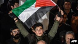 Seorang pria memegang bendera Palestina dalam demonstrasi memprotes usulan perdamaian Timur Tengah dari Amerika Serikat, di depan konsulat AS di Istanbul, Turki, 29 Januari 2020. (Foto: AFP)