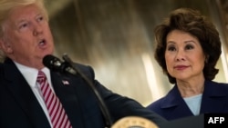 Menteri Transportasi AS Elaine Chao (kanan) mendengarkan pidato Presiden Donald Trump saat rapat infrastruktur di Trump Tower, di New York City, 15 Agustus 2017.