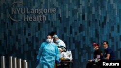 Health workers move a patient wearing a face mask at the at NYU Langone Hospital, during the outbreak of the coronavirus disease (COVID-19) in the Manhattan borough of New York City, New York, May 3, 2020.