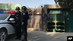 2017年11月2日，在新疆库尔勒市，警察站在一个被认为用于再教育的中心附近。