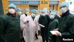 资料照：新冠疫情在武汉爆发初期，世卫组织与中国的医学专家们视察武汉同济医院。（2020年2月23日）