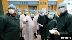 Pakar dari China dan Organisasi Kesehatan Dunia (WHO) mengenakan masker saat mengunjungi Rumah Sakit Wuhan Tongji, pusat wabah virus corona di Hubei, China, 23 Februari 2020. (Foto: China Daily via Reuters)