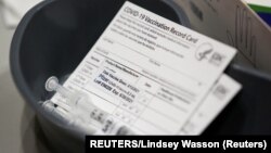 Potvrde o vakcinaciji na jednom od punktova za imnunizaciju (Foto: REUTERS/Lindsey Wasson)