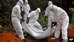 Pekerja kesehatan memakamkan jenazah seorang wanita yang diduga mengalami kematian akibat terjangkit virus Ebola di kabupaten Boumi, pinggiran kota Monrovia, Liberia dalam foto yang diambil pada tanggal 20 Oktober 2014 (foto: AP Photo/Abbas Dulleh)