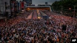 Pro-democracy activists flash three-fingered salutes during a demonstration at Kaset intersection, suburbs of Bangkok, Thailand, Monday, Oct. 19, 2020. 