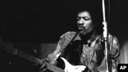 Jimi Hendrix memainkan gitarnya dalam tur di Jerman di Rheinhalle, Dusseldorf, 14 Januari 1969. (AP/Hinninger)