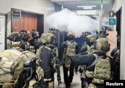 지난해 12월 3일 여의도 국회 내부에 진입한 계엄군이 의회 당직자들과 대치하고 있다.