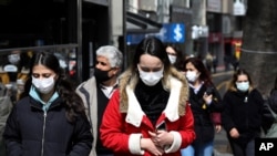 Seorang yang memakai masker untuk membantu melindungi dari penyebaran virus corona, berjalan di Ankara, Turki, Senin, 22 Maret 2021. (Foto: AP)