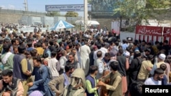 FILE - People try to get into Hamid Karzai International Airport in Kabul, Afghanistan, Aug. 16, 2021.